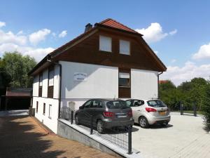 a building with two cars parked in a parking lot at Apartment Weber in Offenheim