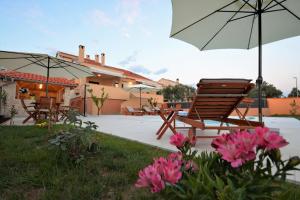 a patio with chairs and an umbrella and flowers at Villa Zupan in Zadar