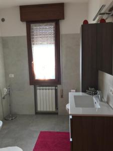 een badkamer met een wastafel en een raam bij Gondola House in Favaro Veneto