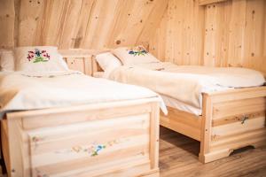 2 letti singoli in una camera con pareti in legno di Domek Folkowa Chata a Poronin