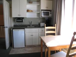 a small kitchen with white cabinets and a table at Brigantine Inn in Lunenburg