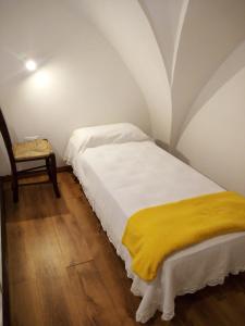 a bedroom with a bed with a yellow blanket on it at Cortile Calinea in Castrignano del Capo