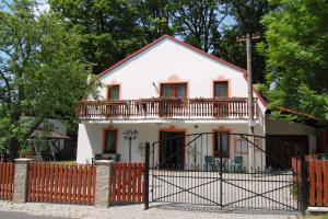 a white house with a gate and a fence at Pension Erika in Františkovy Lázně