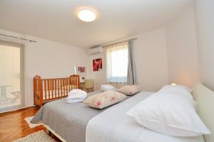 sypialnia z łóżkiem z białą pościelą i poduszkami w obiekcie Villa Zupan w mieście Zadar