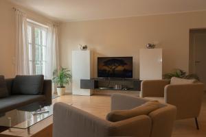 sala de estar con sofá y TV en Traum-Ferienwohnung-am-See, en Sassenberg