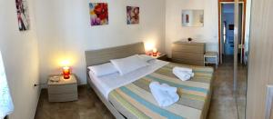 ein Schlafzimmer mit einem Bett mit zwei Lampen und zwei Tischen in der Unterkunft Appartamenti Abbaidda in Valledoria