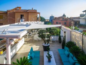 um pátio no último piso com um guarda-sol branco, mesas e cadeiras em Magi House Relais em Sorrento