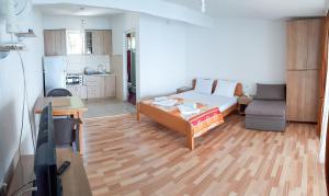 uma sala de estar com uma cama e uma cozinha em Villa Bube em Trpejca