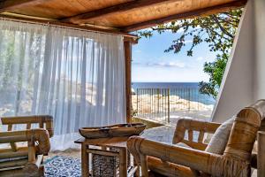 een woonkamer met een bank en uitzicht op de oceaan bij Arbatax Park Resort - Suites Del Mare in Àrbatax