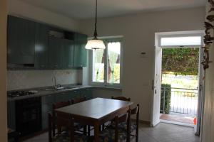 a kitchen with green cabinets and a table and chairs at casa azzurra piano terra in Fetovaia