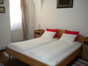 シギショアラにあるPensiunea Bastionのベッドルーム1室(ベッド2台、白と赤の枕付)