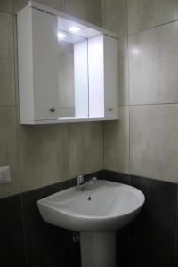 a bathroom with a white sink and a cabinet at Hotel Eduard in Shëngjin