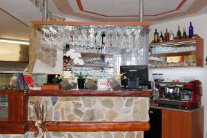 a bar in a restaurant with glasses on the wall at Pension Erika in Františkovy Lázně