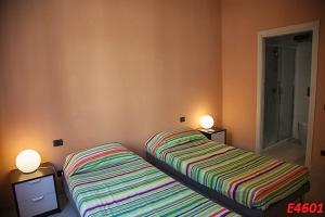 カリアリにあるB&B CIVICO N.21のベッドルーム1室(ベッド2台、ランプ2つ付)