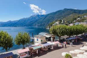 Elle offre une vue sur une ville avec un lac et une montagne. dans l'établissement Al Faro, à Ascona