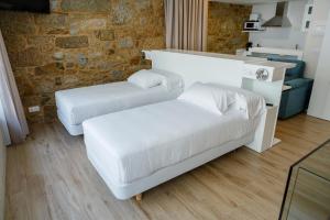 a living room with two beds and a couch at A Bughina apartamentos in Muxia