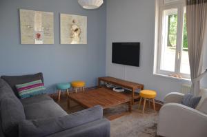 sala de estar con sofá y TV en Gîte du Frêne en Fresnoy-le-Grand