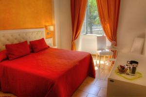 Un dormitorio con una cama roja y una ventana. en Locanda al Viminale, en Roma