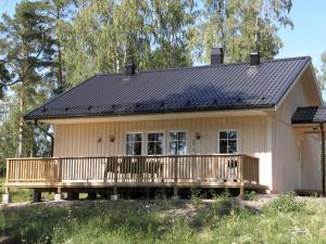 a small house with a porch and a deck at Söderö stugby in Finström