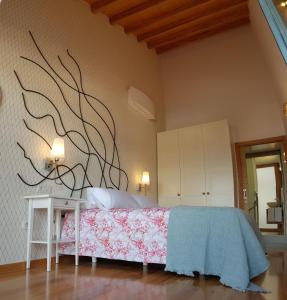 a bedroom with a bed with a painting on the wall at A Casiña de Dina in Finisterre