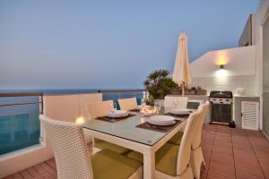 una sala da pranzo con tavolo e sedie sul balcone di Magnificent Seafront 2-bedroom Sliema penthouse a Sliema