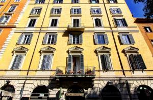 Un gran edificio amarillo con ventanas y balcón. en Locanda al Viminale, en Roma