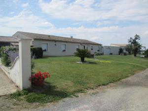 a house with a green yard with a house at Chambre d'Hôtes Les Ormeaux in Saint-Georges-des-Côteaux