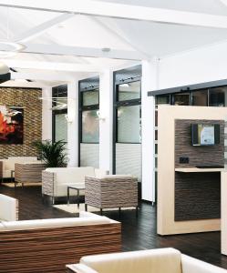 un hall d'entrée avec des canapés, des tables et des fenêtres dans l'établissement Bildungshaus St. Bernhard - Wohnen und Tagen, à Rastatt