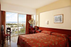 una camera d'albergo con un letto e una grande finestra di Linda a Can Pastilla