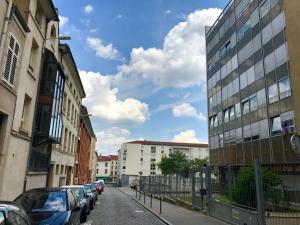 una calle de la ciudad con coches estacionados al costado de la carretera en Petit loft Drouot, en Nancy