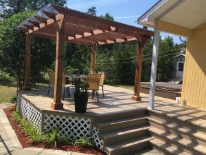 a wooden pergola on a patio with a table at Paradis du Lac Nairne in Notre-Dame-des-Monts