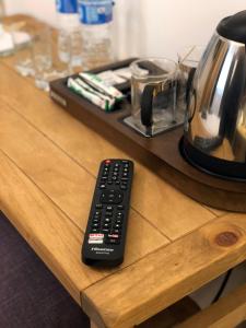 a remote control sitting on top of a wooden counter at Bradley's Bed & Breakfast in Strabane