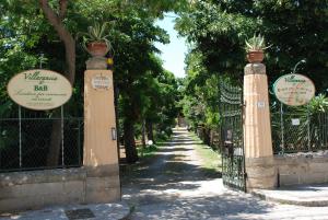 une porte menant à un parc avec des plantes dans l'établissement Villarancia, à Alezio