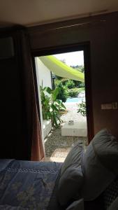 a door to a bedroom with a view of a backyard at A Sulana Chambre d'hôtes in Valle-di-Campoloro +58 photos