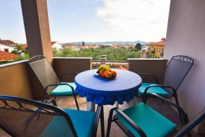 una mesa con un bol de fruta en el balcón en Apartments Kostijal en Zadar
