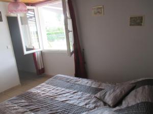 a bedroom with a bed with a window in it at Chambre d'Hôtes Les Ormeaux in Saint-Georges-des-Côteaux