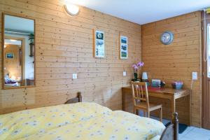 a bedroom with a bed and a wooden wall at B&B Gottardo in Airolo