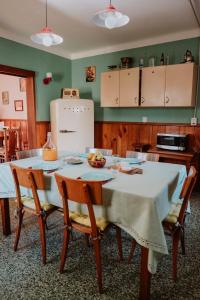 a kitchen with a table with chairs and a refrigerator at Kospi Boutique Guesthouse in San Carlos de Bariloche