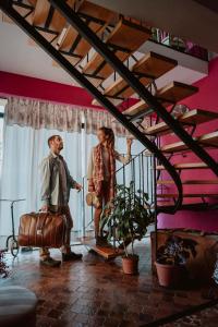 a man and woman standing in a room with a suitcase at Kospi Boutique Guesthouse in San Carlos de Bariloche