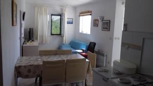 ein Wohnzimmer mit einem Tisch und einem Sofa in der Unterkunft Iva in Prvić Šepurine