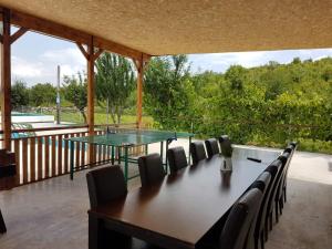 a patio with a ping pong table and chairs at Holiday Home Poljičko Imanje in Donji Dolac