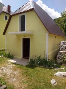 ein gelbes Haus mit einer Tür im Hof in der Unterkunft Bujtina Ahmetaj in Valbonë