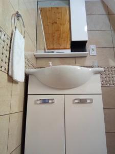 y baño con lavabo blanco y espejo. en Bujtina Ahmetaj en Valbonë