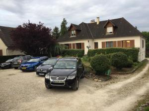 un grupo de autos estacionados frente a una casa en Gite Le Plessis, en Chailles