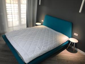 a bed with a blue headboard in a bedroom at Brand new luxurios loft by the sea in Mamaia Nord