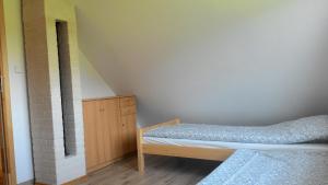 a small bedroom with a bed and a dresser at Domek Letniskowy przy lesie in Kruklanki
