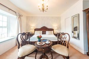 a bedroom with a bed and a table and chairs at The Blue Haven Hotel in Kinsale