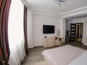 a bedroom with a bed and a flat screen tv at 1 Bedroom Flat near Shopping Malldova! in Chişinău