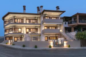 a large apartment building with stairs in front of it at Pleiades Casual Living in Nea Roda
