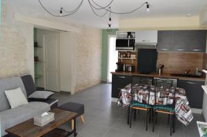 a kitchen and living room with a couch and a table at Gîtes sympa, prés du zoo de beauval, "Au Havre de Paix" in Couffy